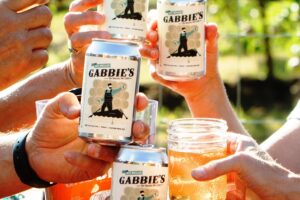 people holding cans of big belle cider